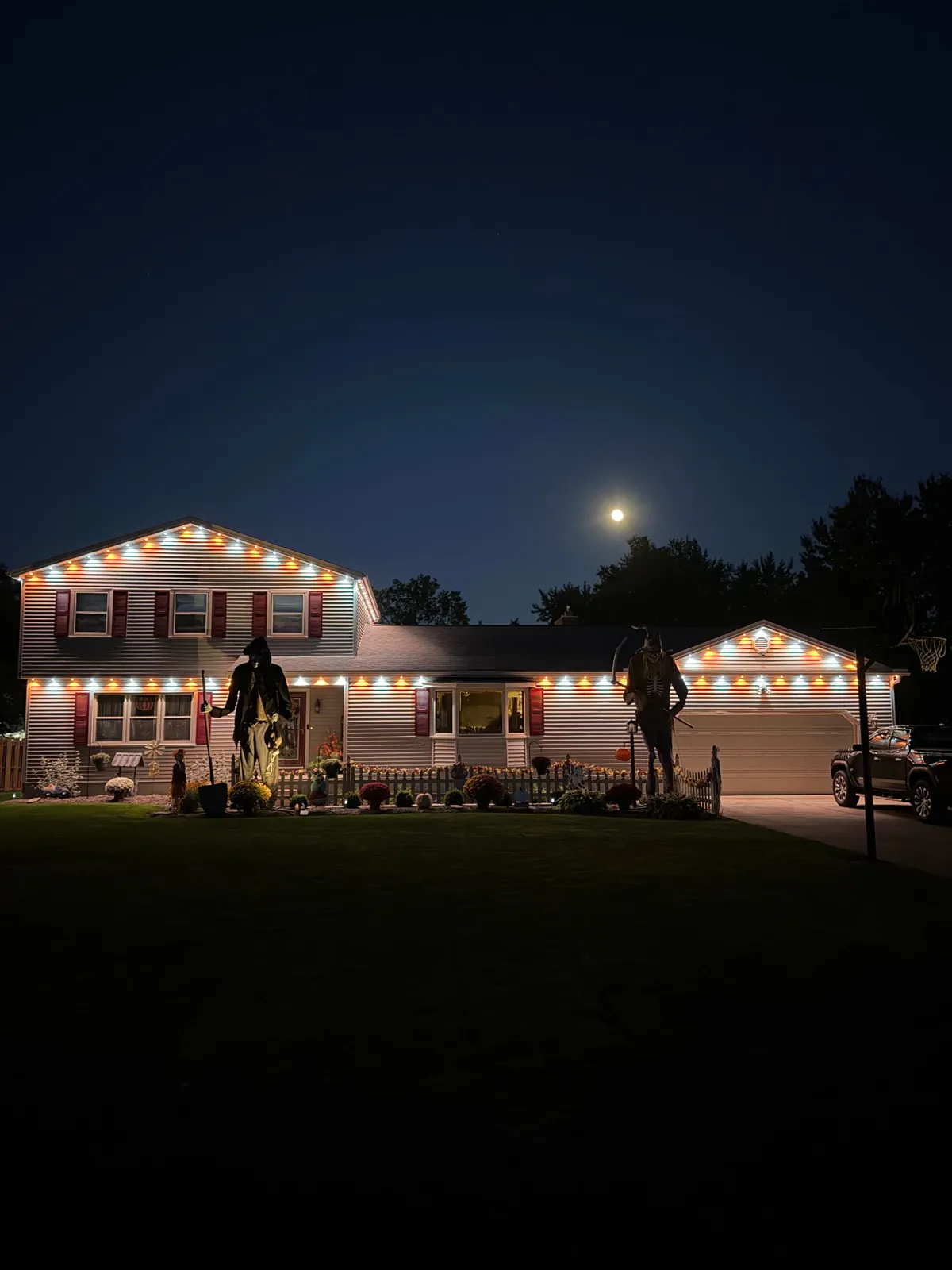 Home lit orange and white for Halloween with permanent lighting