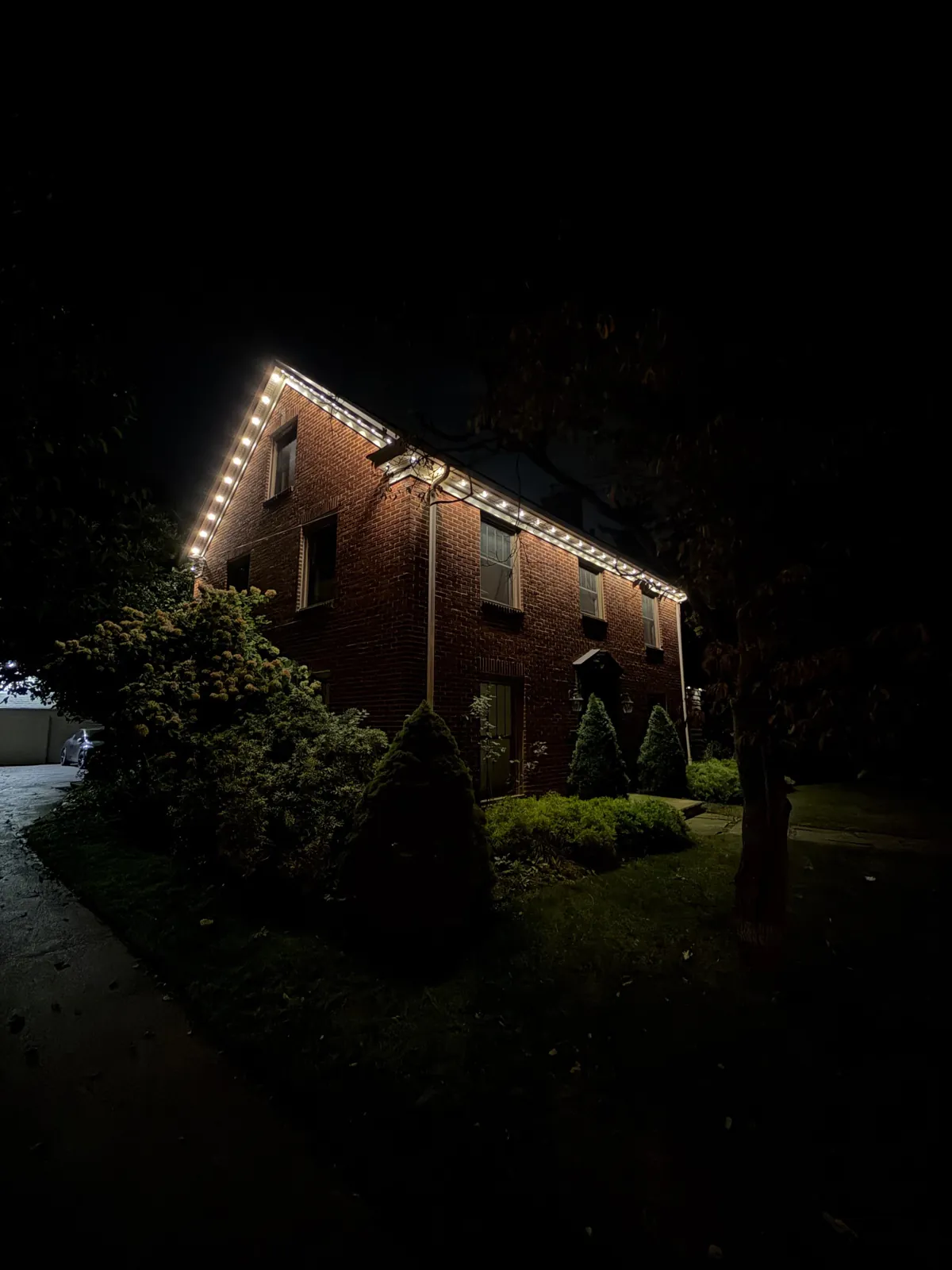 Brick home with crisp white permanent roofline lighting